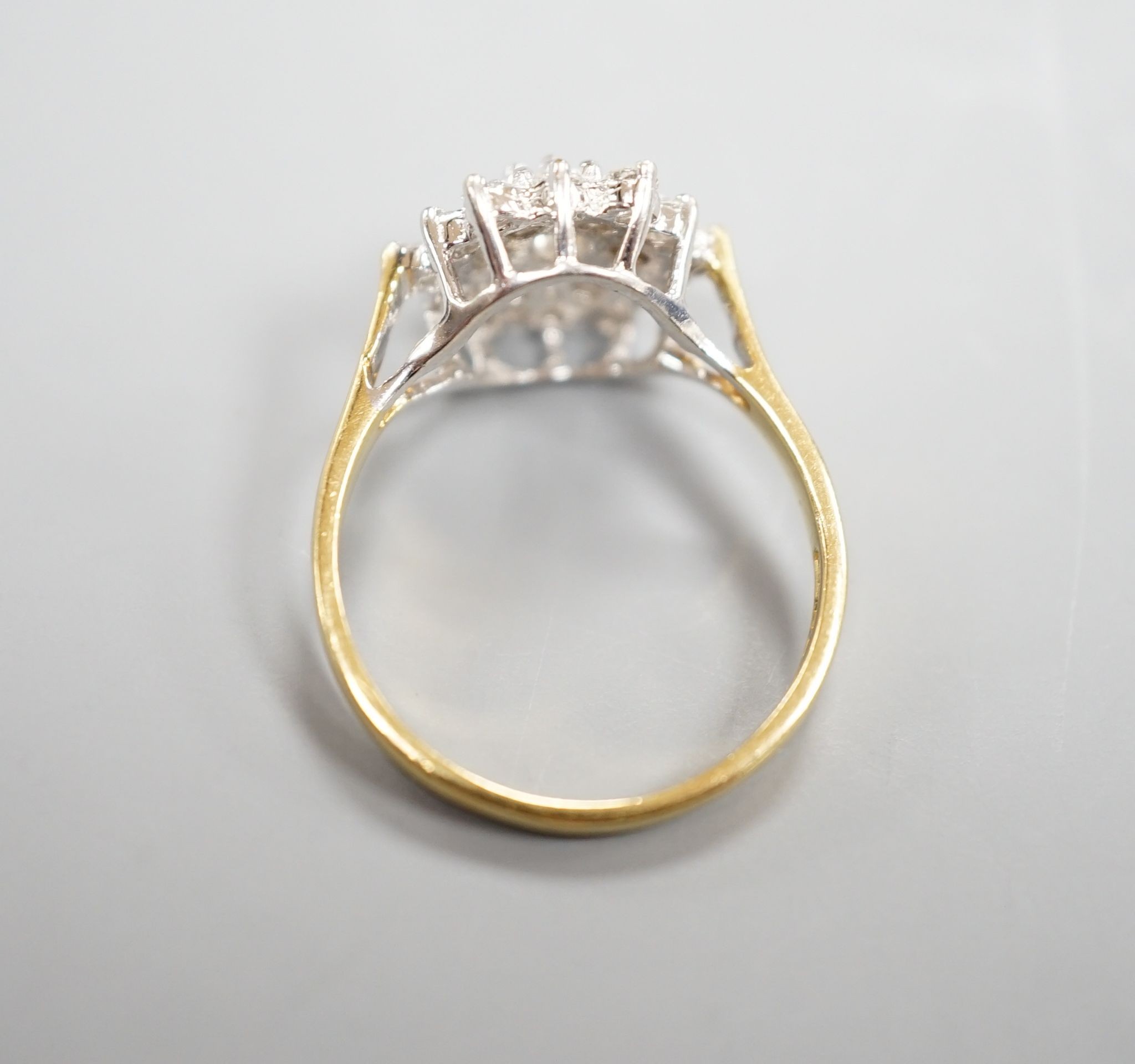 A modern 750 yellow metal and diamond set hexagonal cluster ring, size O, gross weight 3.4 grams.